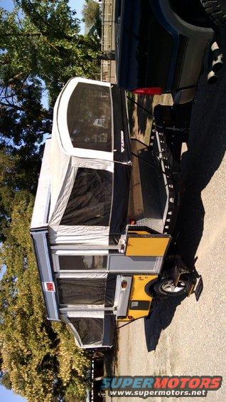 Pop-up camper trailer hitched to a truck bed