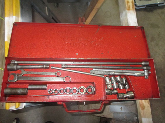 Red metal tool chest open, showing sockets, wrenches, and extensions