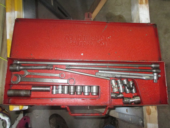 Red metal tool chest open, filled with sockets, wrenches, and extensions