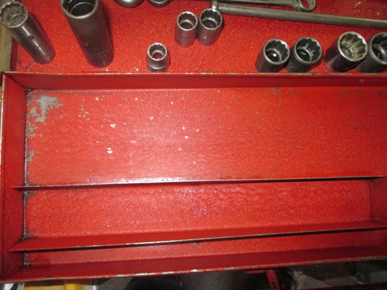 Socket wrenches and a ratchet in a red metal toolbox