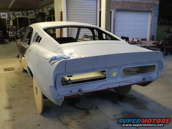 Car body in primer, rear view, undergoing restoration