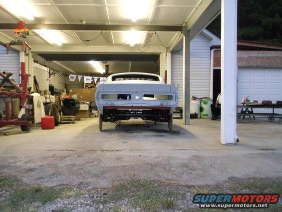 1967 Ford Mustang rear view, undergoing restoration in a garage