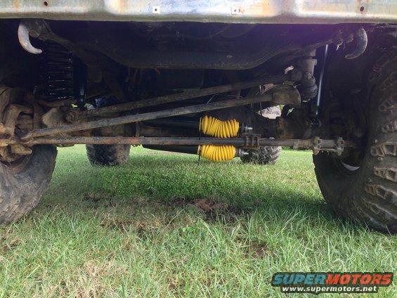Undercarriage view of a 4x4 with yellow shock boots and large tires