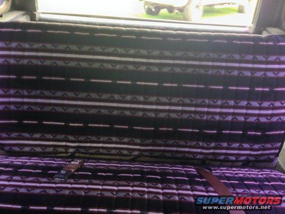 Interior view of a vehicle showing patterned seats and a seatbelt