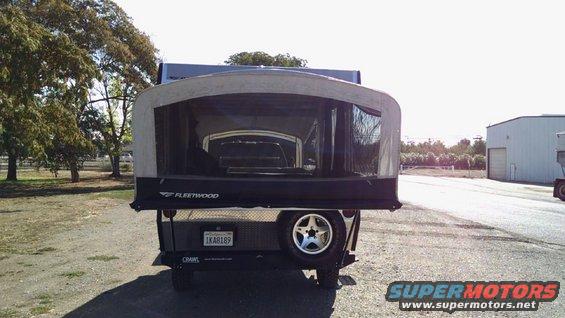 Pop-up camper trailer with Fleetwood branding, spare tire, and license plate 1KA8189