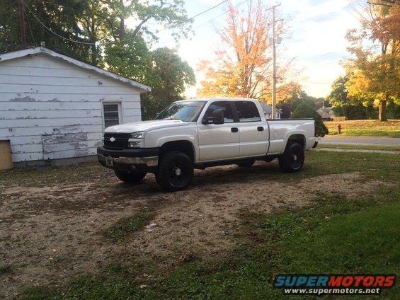 White 2006 Chevrolet Silverado 2500 pickup truck parked in a yard next to a white shed