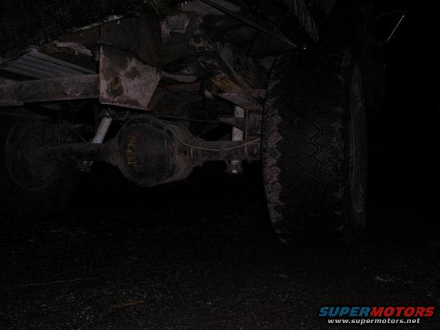 Underside view of a vehicle's rear axle and tire