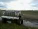 1980 Ford Bronco - Ford Bronco stuck in a muddy field under a cloudy sky.