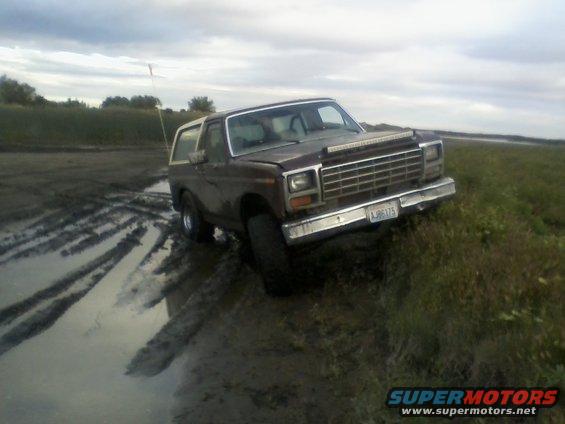 1980 Ford Bronco stuck in mud with a light bar on the grille