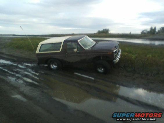 Brown and white 1980 Ford Bronco in mud