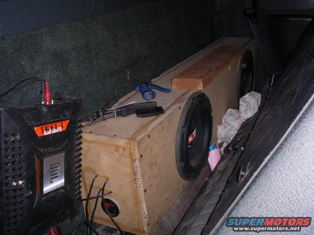 JBL amplifier and custom subwoofer box with two 12-inch speakers inside a vehicle