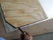 1992 Ford Bronco - A hand uses a pencil to trace a shape onto a piece of plywood laid over a metal sheet.