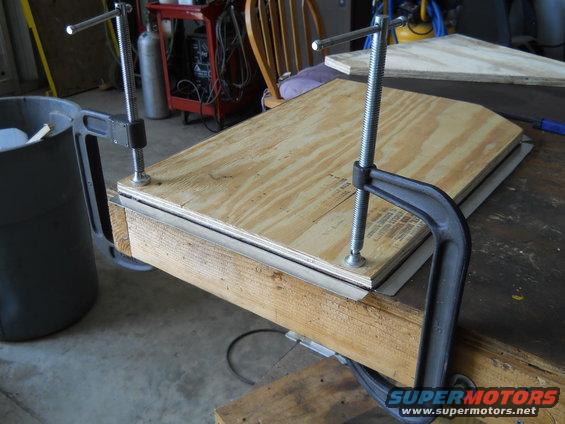 Plywood clamped to workbench with C-clamps