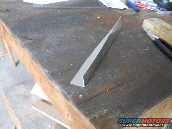 Metal trim piece on a wooden workbench