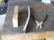 1992 Ford Bronco - Tools and a metal part laid out on a wooden workbench surface.