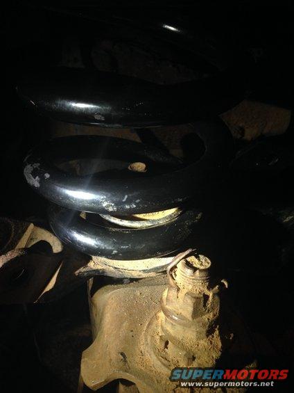 Close-up of a vehicle's suspension spring and ball joint assembly