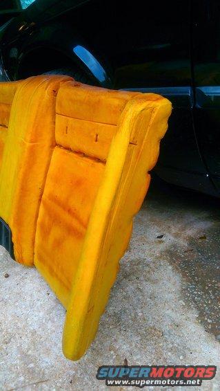 Yellow foam from a car seat, with a black car in the background