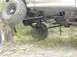 1996 Ford Bronco - The undercarriage of a vehicle is shown with one wheel elevated on a tree trunk in a wooded area.