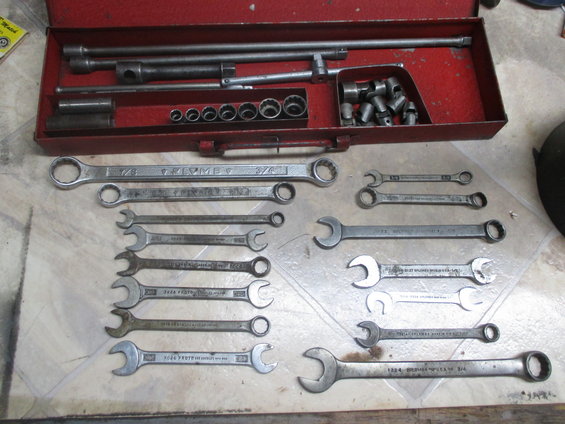 Red metal tool chest open, filled with various wrenches and sockets