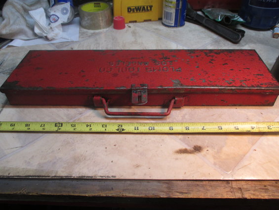 Red metal toolbox with a handle and latch, marked "PLOMB TOOL CO. LOS ANGELES."