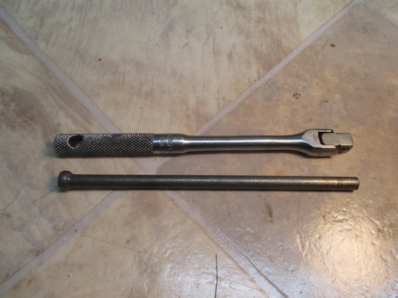 socket wrench and extension bar on a tiled floor