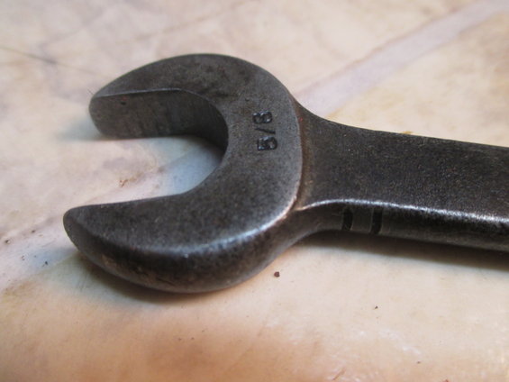 Close-up of a metal wrench with '5/8' stamped on it