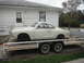1969 Volkswagen Karmann Ghia - A white 1969 Volkswagen Karmann Ghia is seen being transported on a trailer in front of a white house.