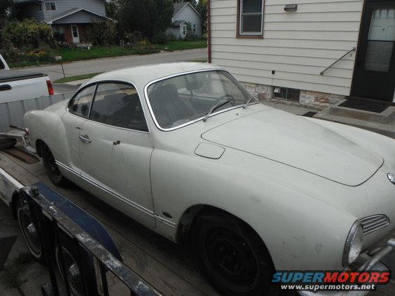 White 1969 Volkswagen Karmann Ghia coupe on a trailer, front quarter view, showing some dirt and wear