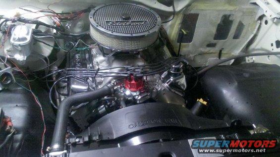Engine bay with Edelbrock air cleaner and red distributor cap. Caution Fan text visible on fan shroud