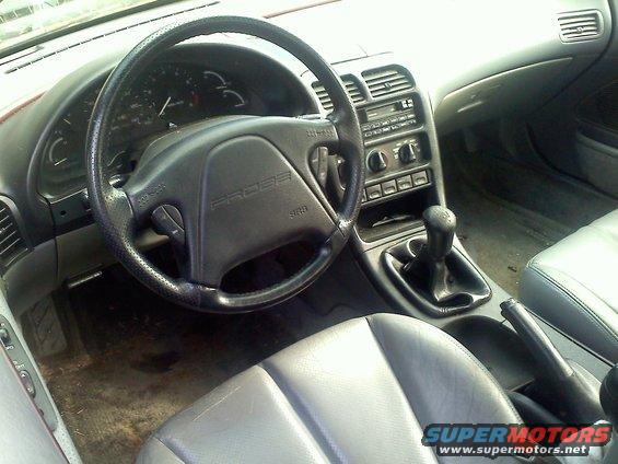 1993 Ford Probe GT interior showing dashboard, steering wheel with 'PROBE' logo, center console with shifter, and gray seats