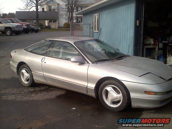 Silver 1993 Ford Probe GT coupe parked outside a garage