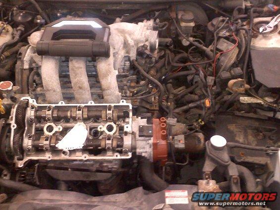 Engine bay showing camshafts and intake manifold with valve cover removed