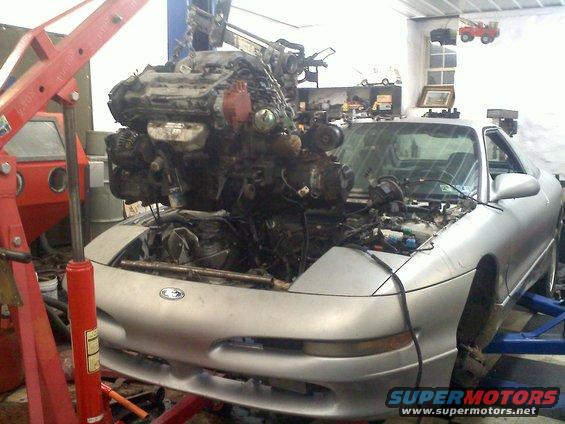 1993 Ford Probe GT with engine being lifted out by a red engine hoist