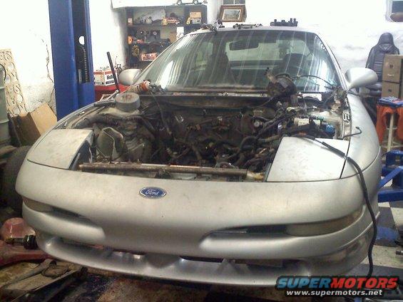 Silver 1993 Ford Probe with hood open, engine exposed, in a garage