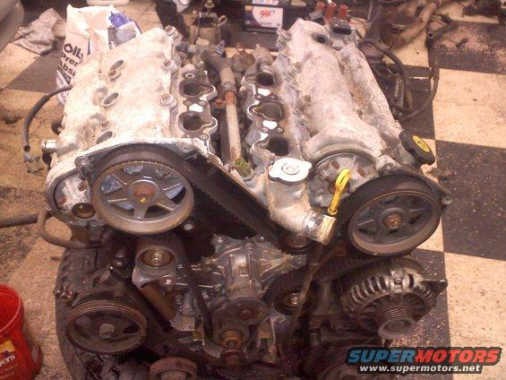 Engine with timing belt and pulleys, dirty aluminum finish, front view