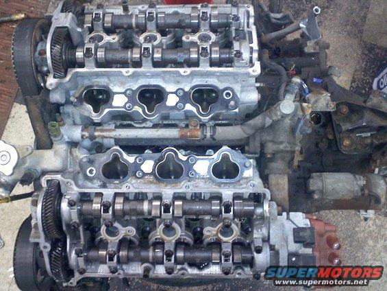 Engine block showing camshafts and intake ports. Water pump and starter motor visible