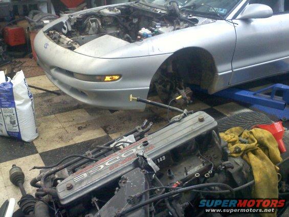 Silver car front view, hood open, engine removed