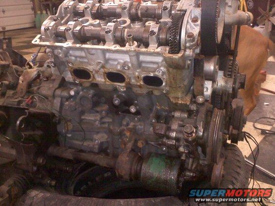 engine block with camshafts and timing belt visible