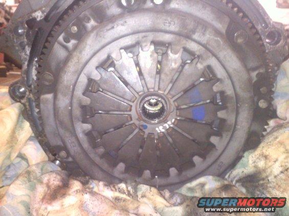 Close-up of a car's clutch assembly with a flywheel and pressure plate visible