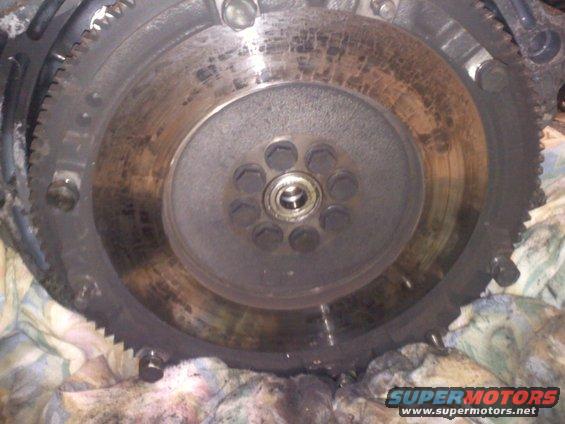 Engine flywheel with visible wear marks and bolt holes