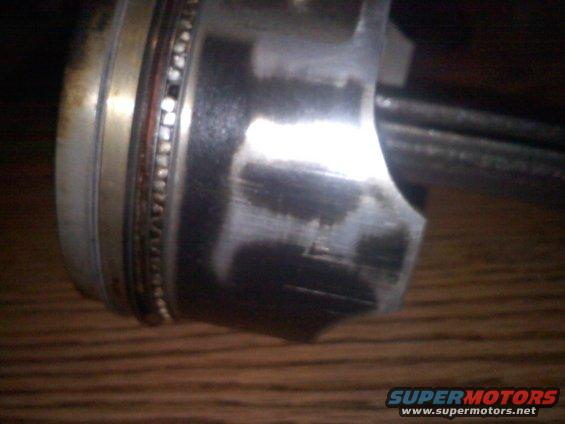 Close-up of a worn piston with scoring marks and a bearing ring