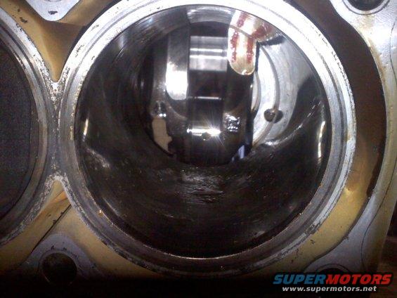 Close-up view inside an engine cylinder, showing the crankshaft and connecting rod