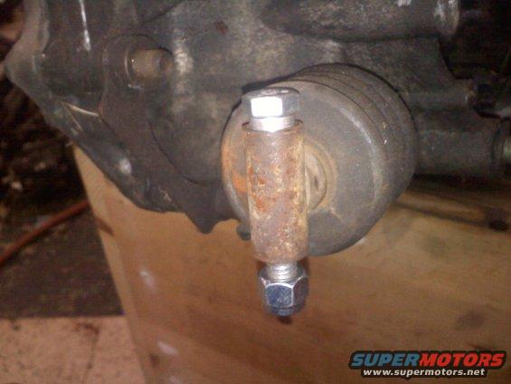 close-up of a rusty bolt and nut on a vehicle suspension part