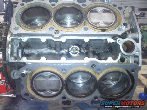 Engine block with six cylinders, showing pistons and internal components