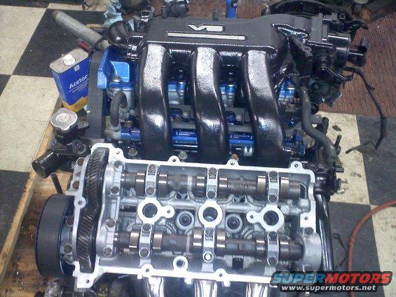 V6 engine assembly showing intake manifold, fuel injectors, and exposed camshafts