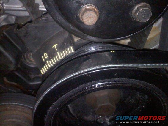 Close-up of an engine belt tensioner with markings indicating '10 T' and a scale