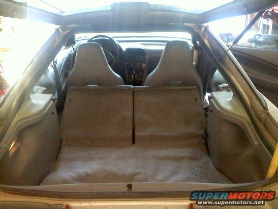 Back seats and cargo area of a car, looking forward towards the dashboard and steering wheel
