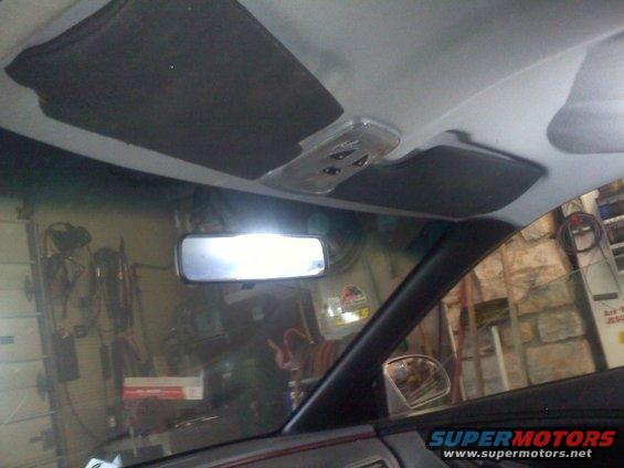 Interior view of a car's headliner, sun visors, rearview mirror, and passenger side window