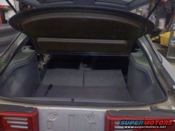 1993 Ford Probe GT trunk interior with carpeted floor and side panels. A screwdriver rests on the floor
