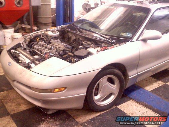 Silver 1993 Ford Probe GT coupe, front passenger side view, hood open, engine exposed, in a garage